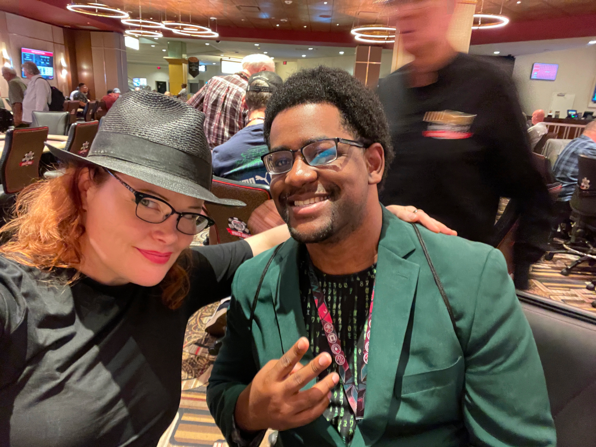 Ohm-I in a green jacket hosting the poker tournament alongside Tarah Wheeler.