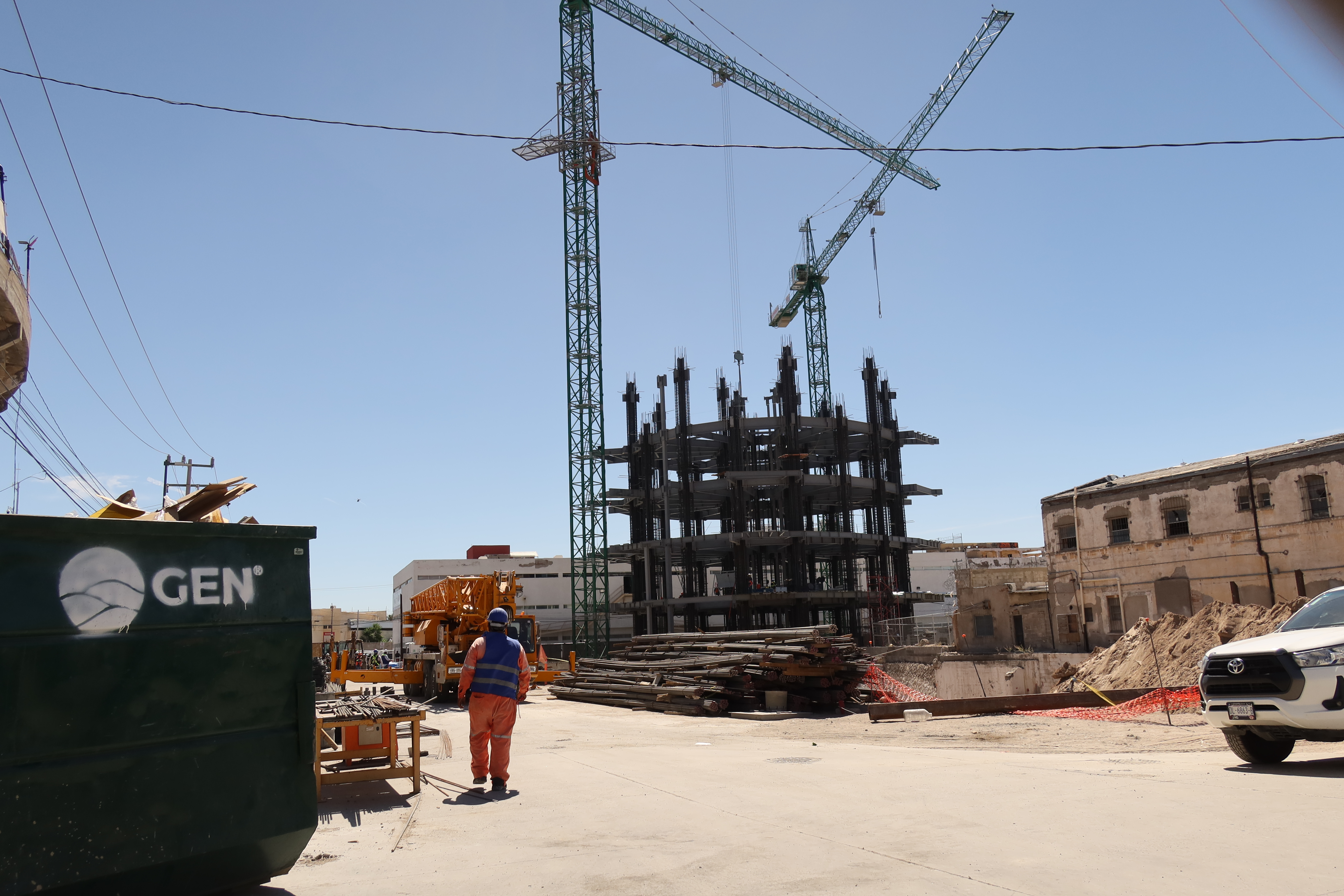 A construction site with a crane and the first few floors of a skyscraper.